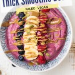 A close up at 3 thick smoothie bowls with toppings.