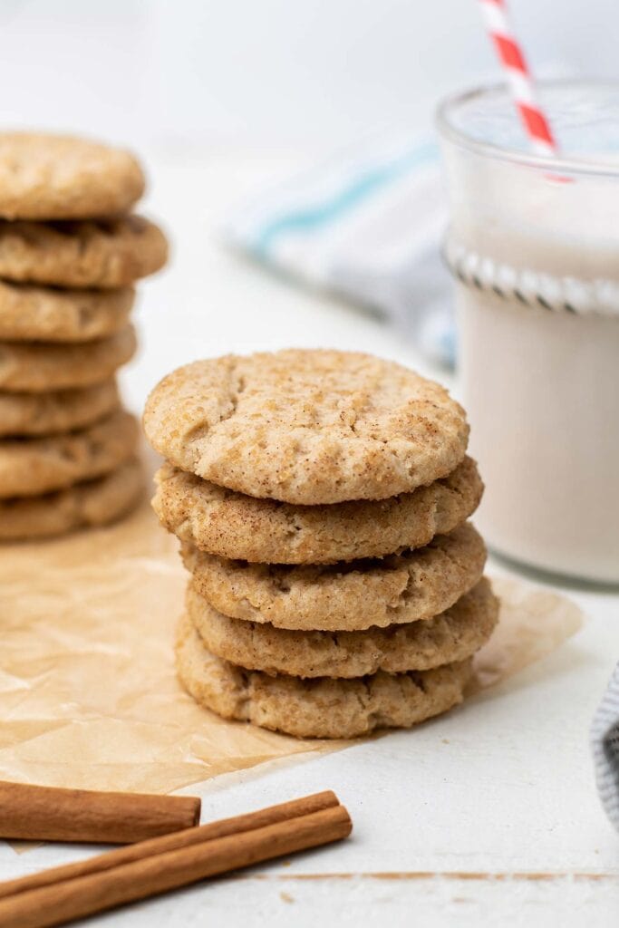 A stack of gluten free snickerdoodles in front of a glass of milk.