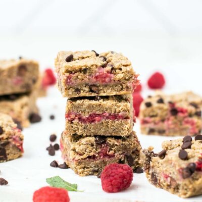 A stack of 3 oatmeal cookie bars shown with a raspberry filling.