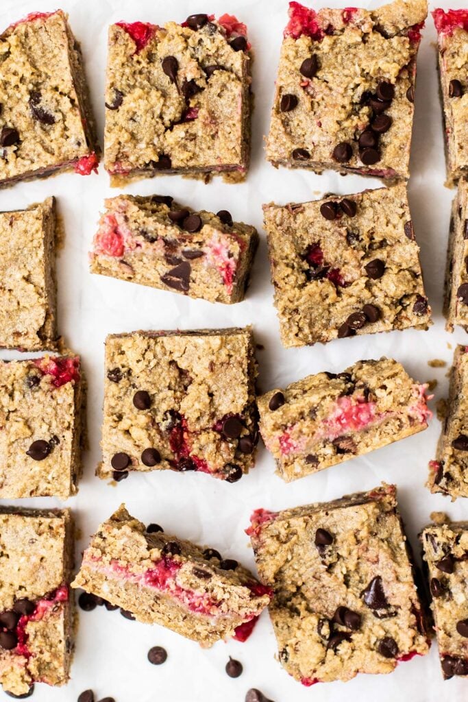 Oatmeal Cookie Bars shown cut into squares with a bright pink raspberry filling.