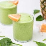 A vibrant green metabolism boosting smoothie shown garnished with grapefruit.