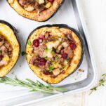 Baked acorn squash shown stuffed with sausage and vegetables.