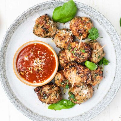 A plate of turkey meatballs made in the air fryer served with marinara sauce.