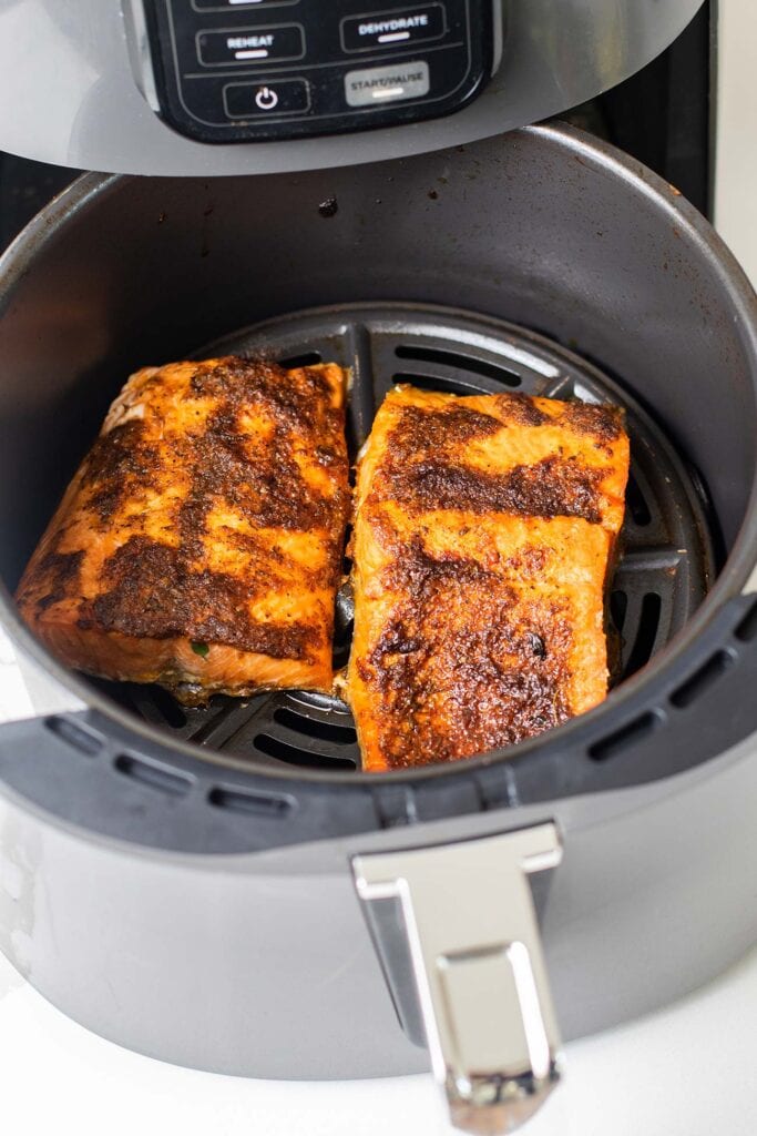A ninja air fryer shown with salmon.