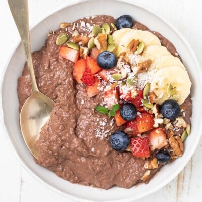 A bowl of chocolate chia seed pudding topped with berries, bananas, and nuts.