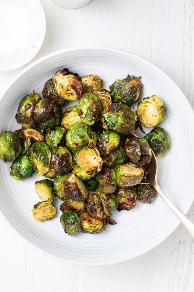 A bowl of air fryer brussels sprouts, perfectly crispy on the outer leaves.
