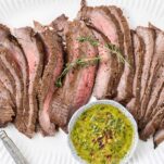 A thinly sliced london broil on a white platter.