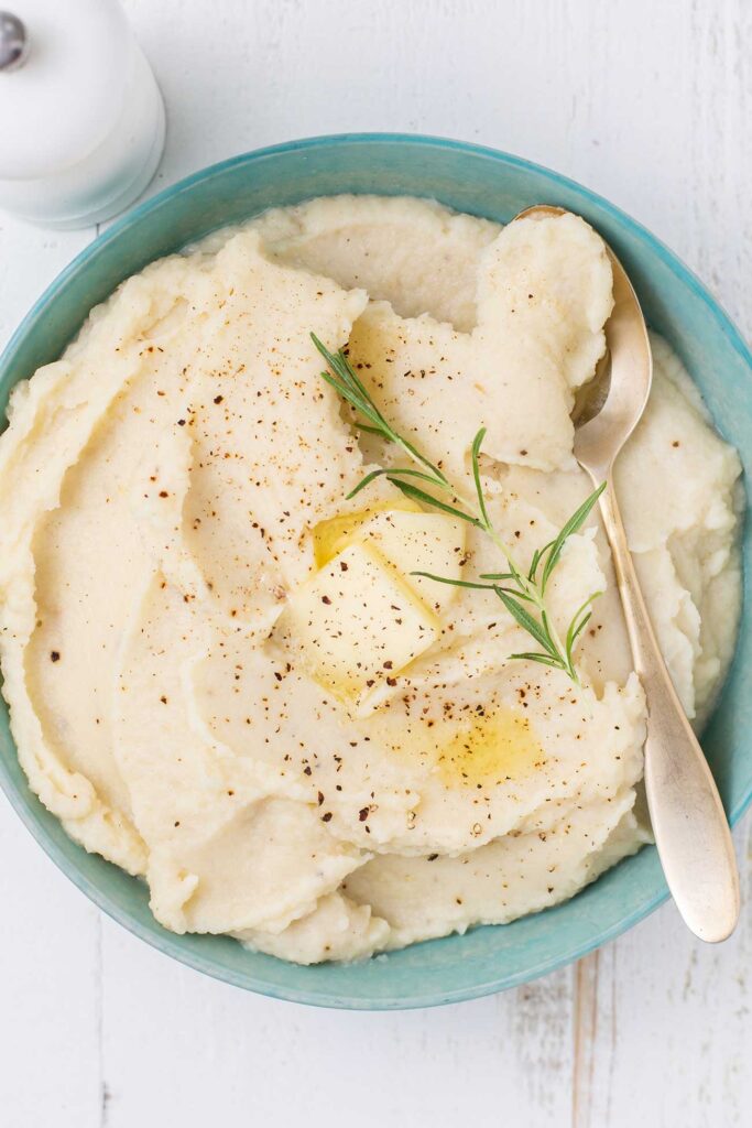 A blue bowl with cauliflower mash, showing the thick and creamy texture.