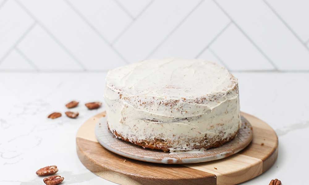A layer cake shown with a thin layer of frosting known as a crumb coat.
