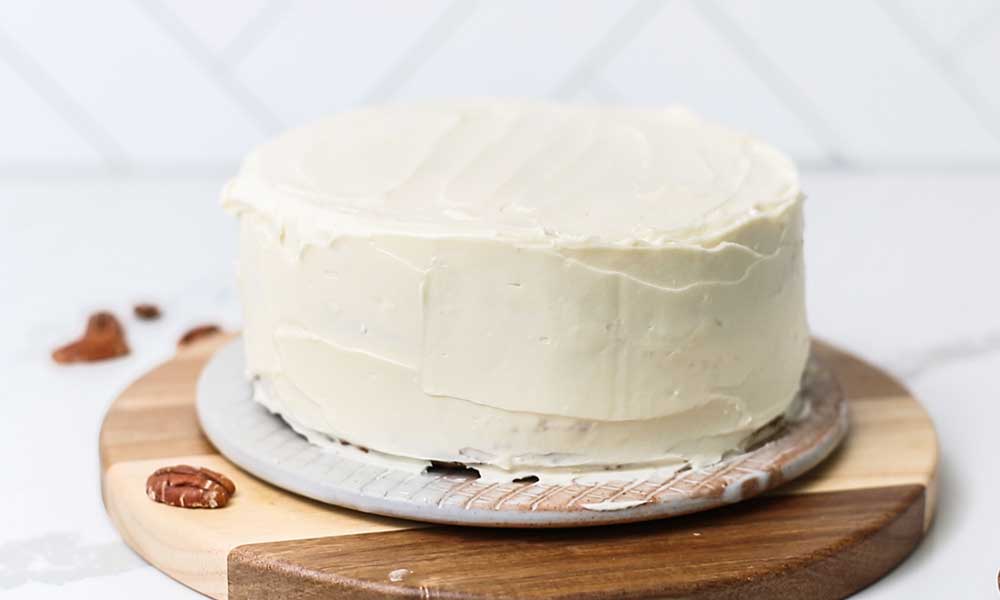 A layer cake shown iced with a thick layer of cream cheese.