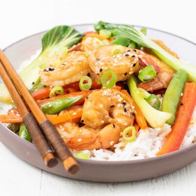 A healthy shrimp stir fry shown served on a plate over rice.