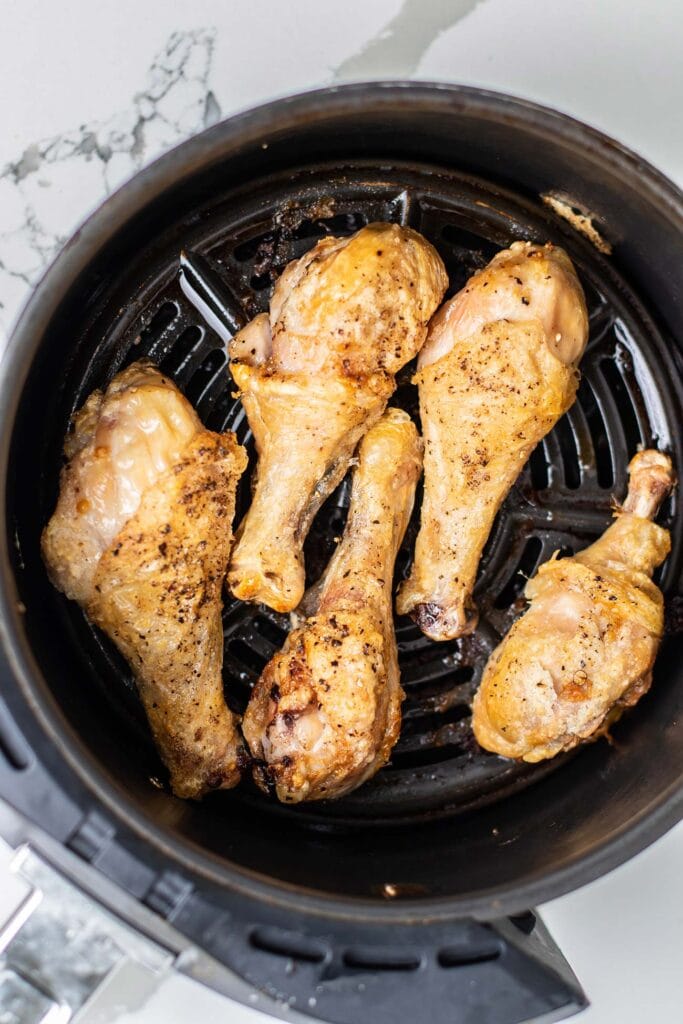 Crispy, golden brown chicken legs fried in an air fryer.