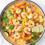 A white pan with a vibrant vegetable and shrimp curry.