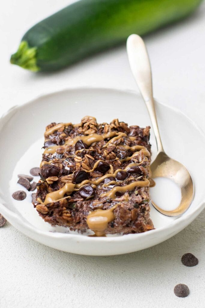 A slice of chocolate baked oats shown drizzled with nut butter.