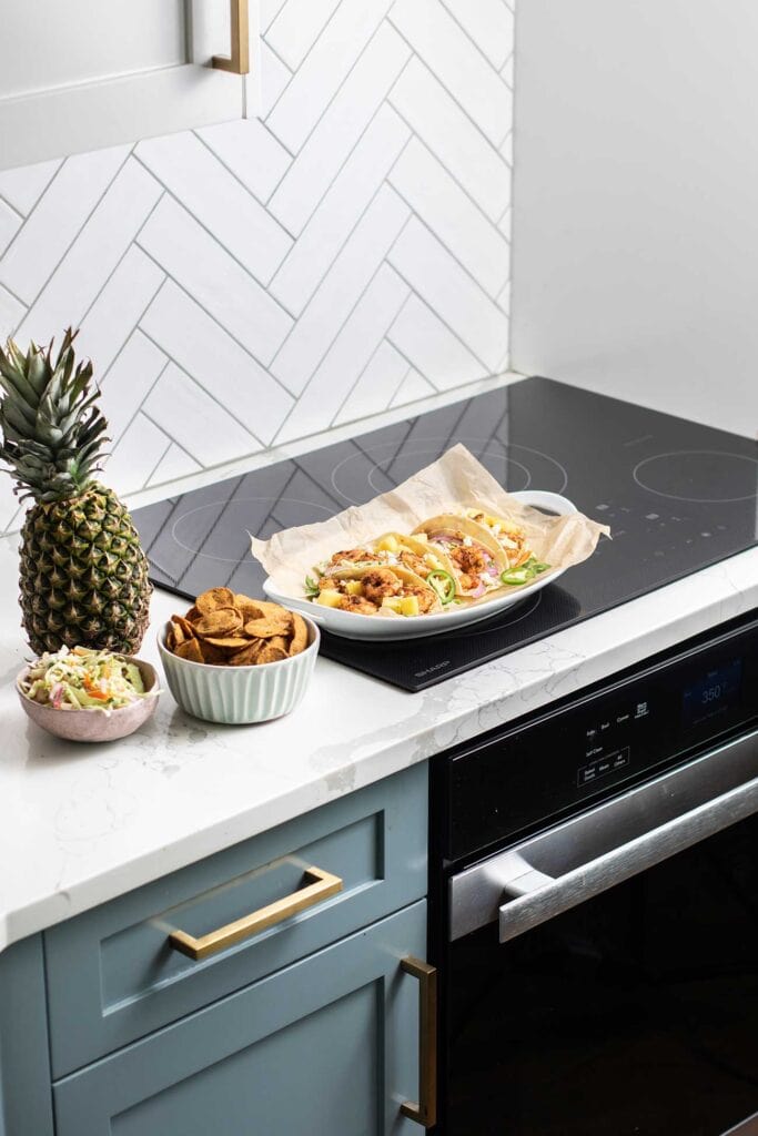 A sharp induction cooktop shown with a platter of spicy shrimp tacos.