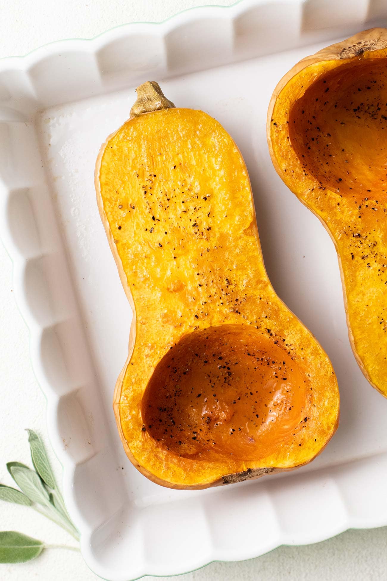 A roasted butternut squash shown in a baking dish.