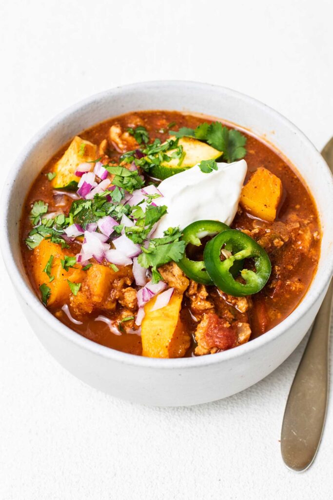 A bowl of paleo turkey chili shown garnished with jalapeno and cilantro.