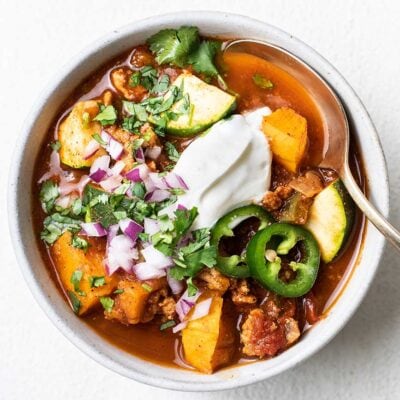 A bowl of paleo turkey chili shown topped with sour cream and cilantro.