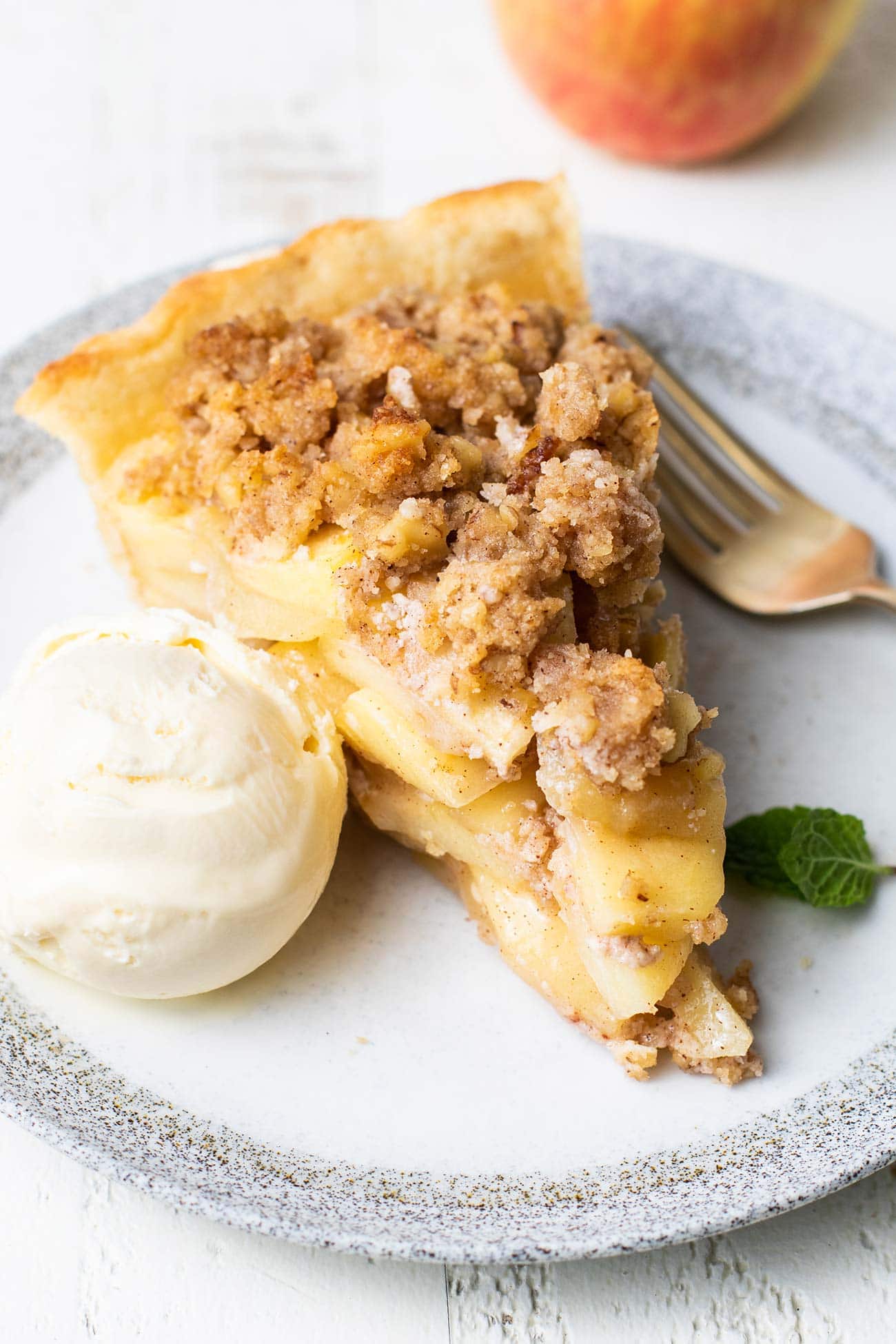 A slice of gluten free apple pie served with ice cream.