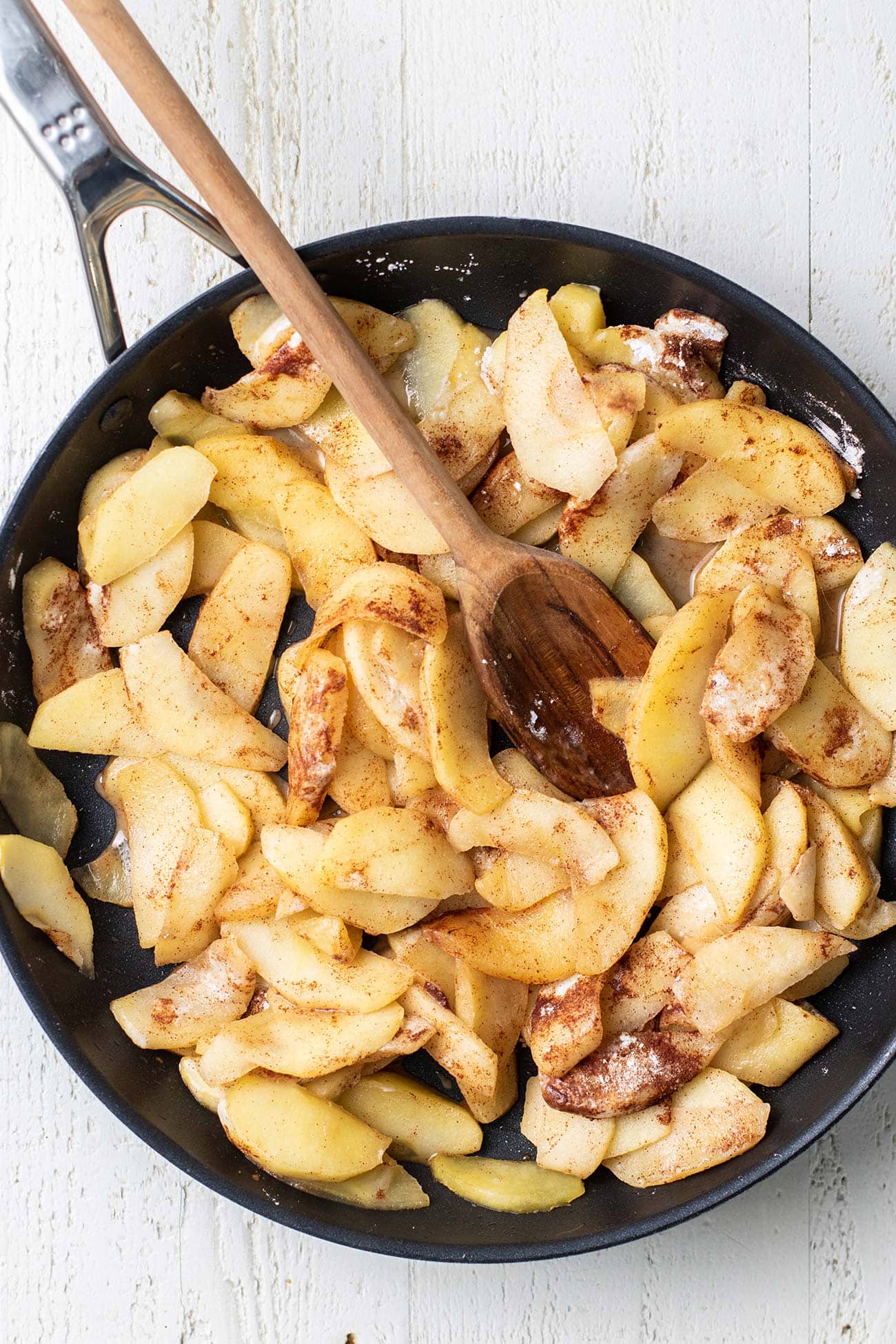 Apple slices in a skillet sprinkled with cinnamon and arrowroot.
