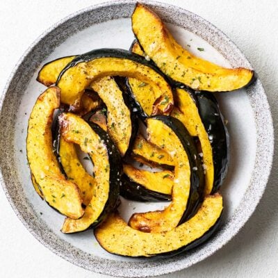 A plate of roasted acorn squash sprinkled with coarse sea salt.