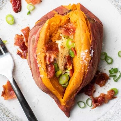 A sweet potato prepared in an Instant Pot and served with butter, bacon, and green onions.