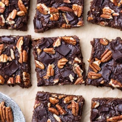 A batch of sweet potato brownies shown topped with pecans and sliced in squares.