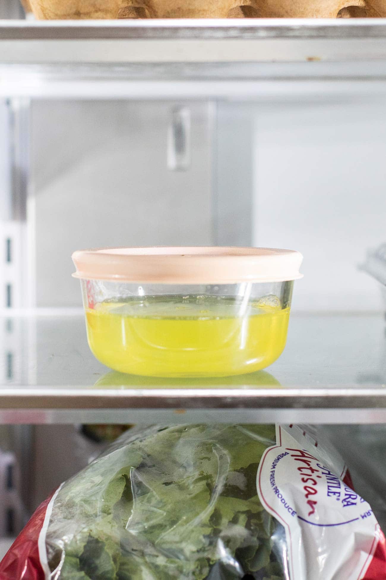 Egg whites in a glass container in the refrigerator.
