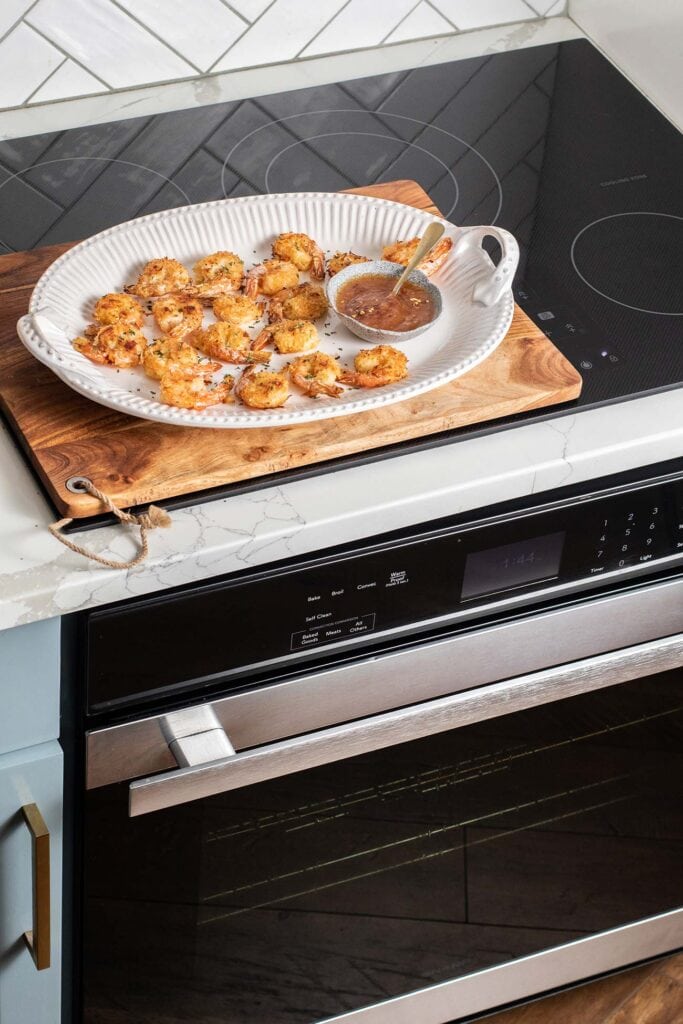 A platter of coconut shrimp shown sitting on top of the Sharp European Convection Oven.