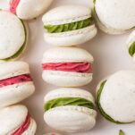 White vanilla bean French macarons shown with vibrant raspberry and matcha peppermint filling.