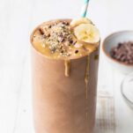 A thick chocolate smoothie drizzled with SunButter and topped with cocoa nibs.