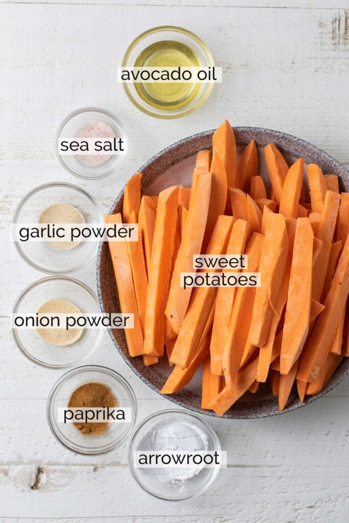 Sweet potatoes shown cut into fry shapes with the additional ingredients needed to make the perfect sweet potato fries.