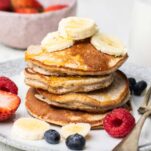 Buckwheat pancakes shown drizzled with honey and topped with banana.