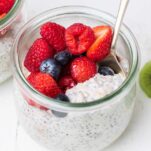 A spoon scooping up some overnight oats with yogurt topped with berries.