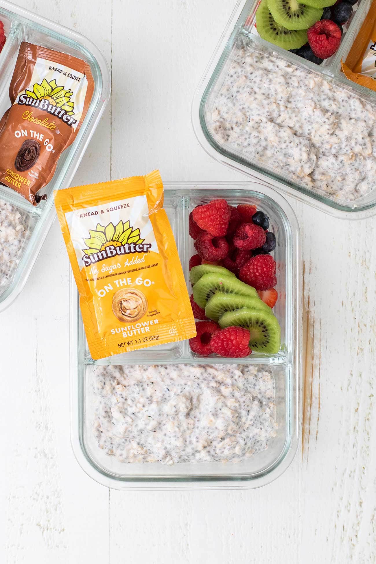 Overnight oats packed in meal prep containers with toppings.