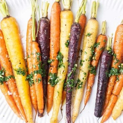 Roasted Rainbow Carrots shown drizzled with chimichurri.