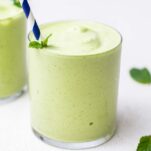 A green peppermint smoothie shown with a blue straw.