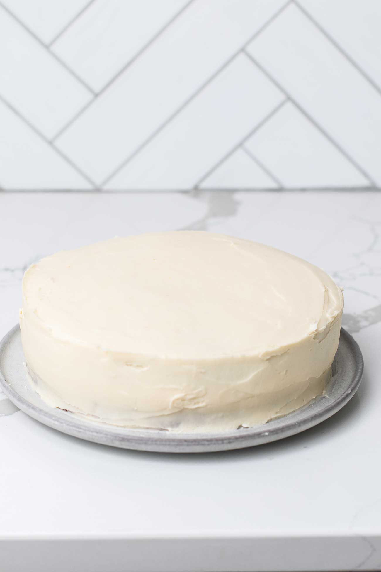 A thick even layer of cream cheese frosting on a carrot cake.
