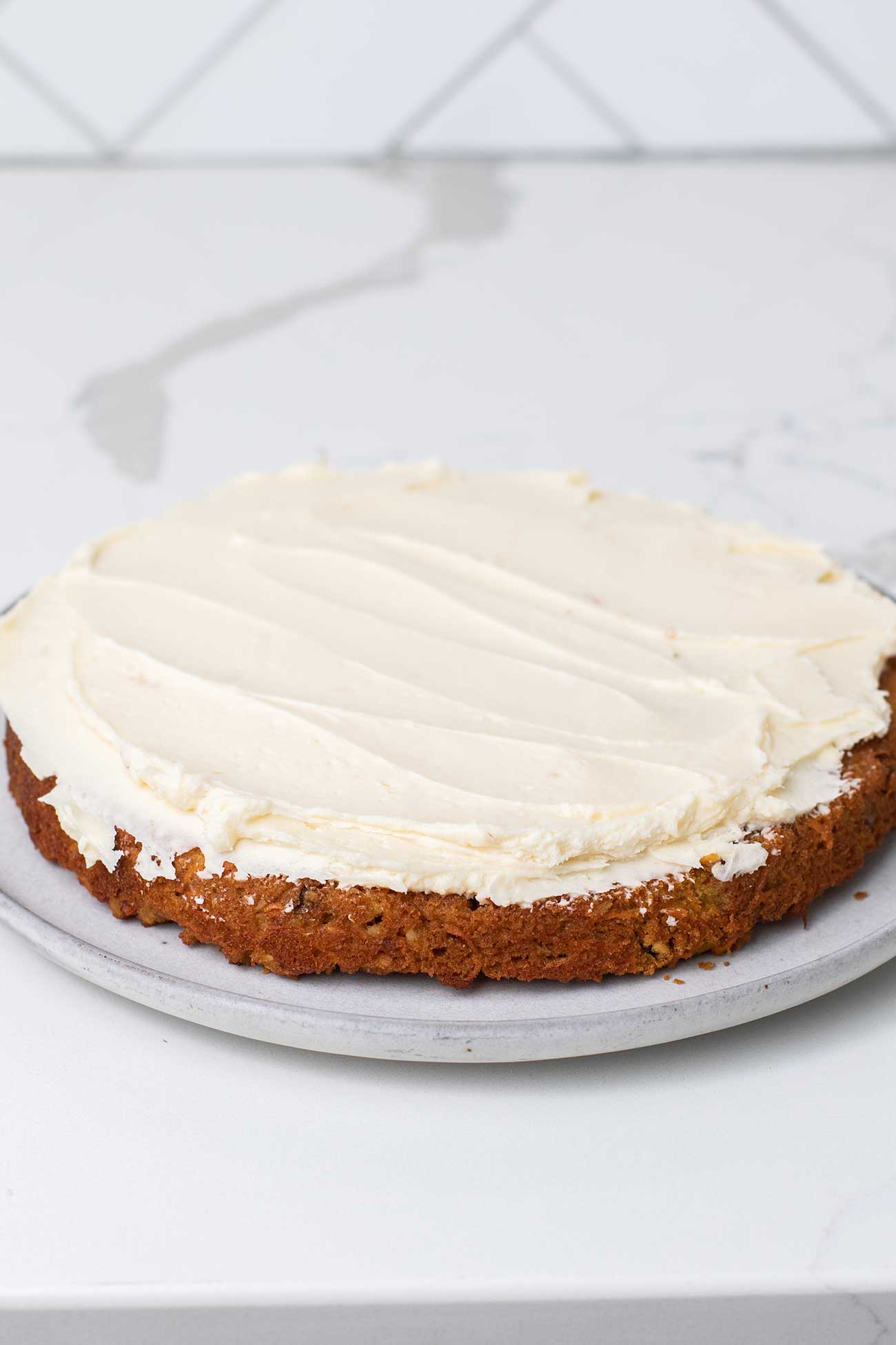 1 layer of the carrot cake topped with a thick layer of cream cheese frosting.