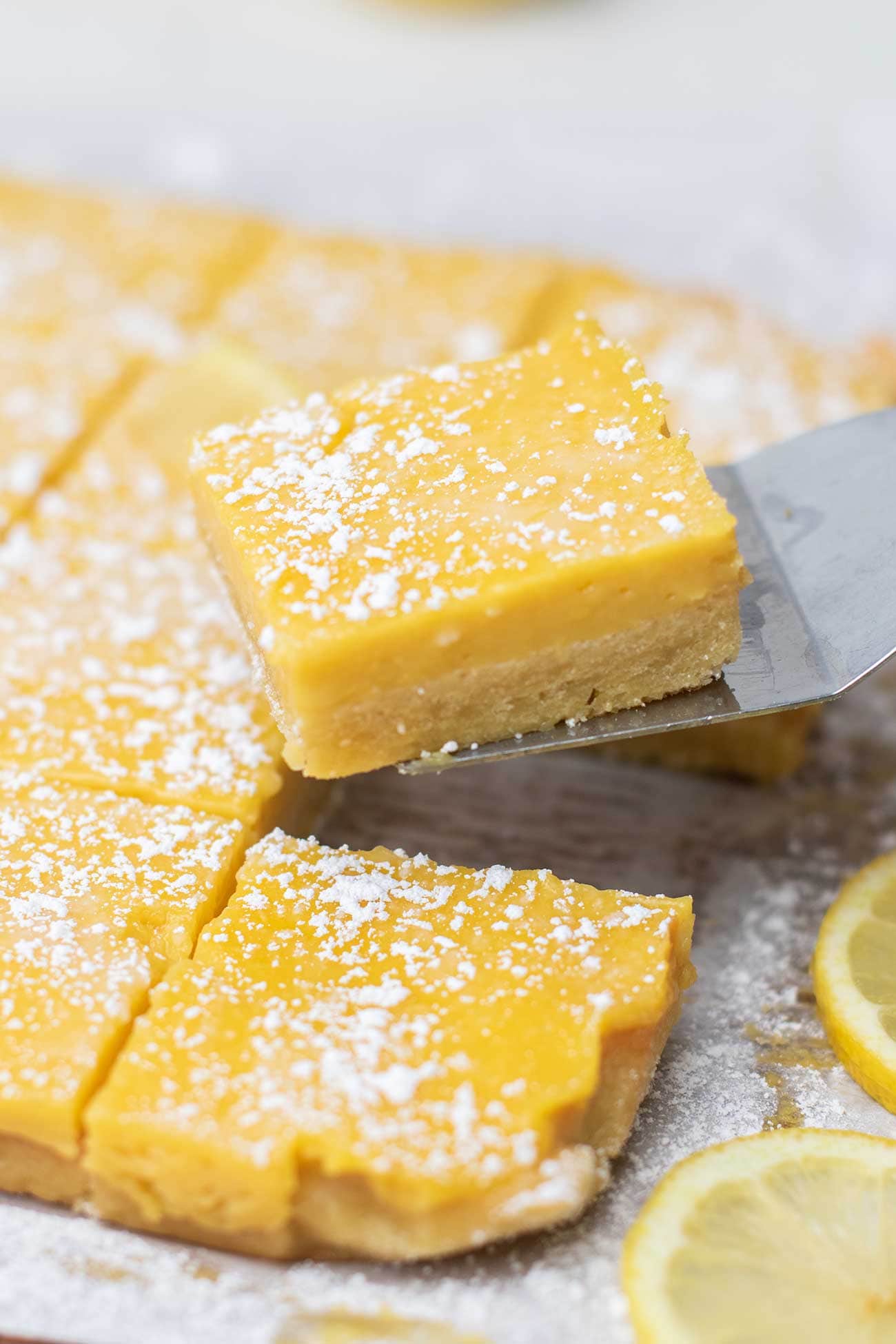 A lemon bar cut into a perfect square.