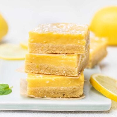Lemon Bars stacked on a blue cutting board.