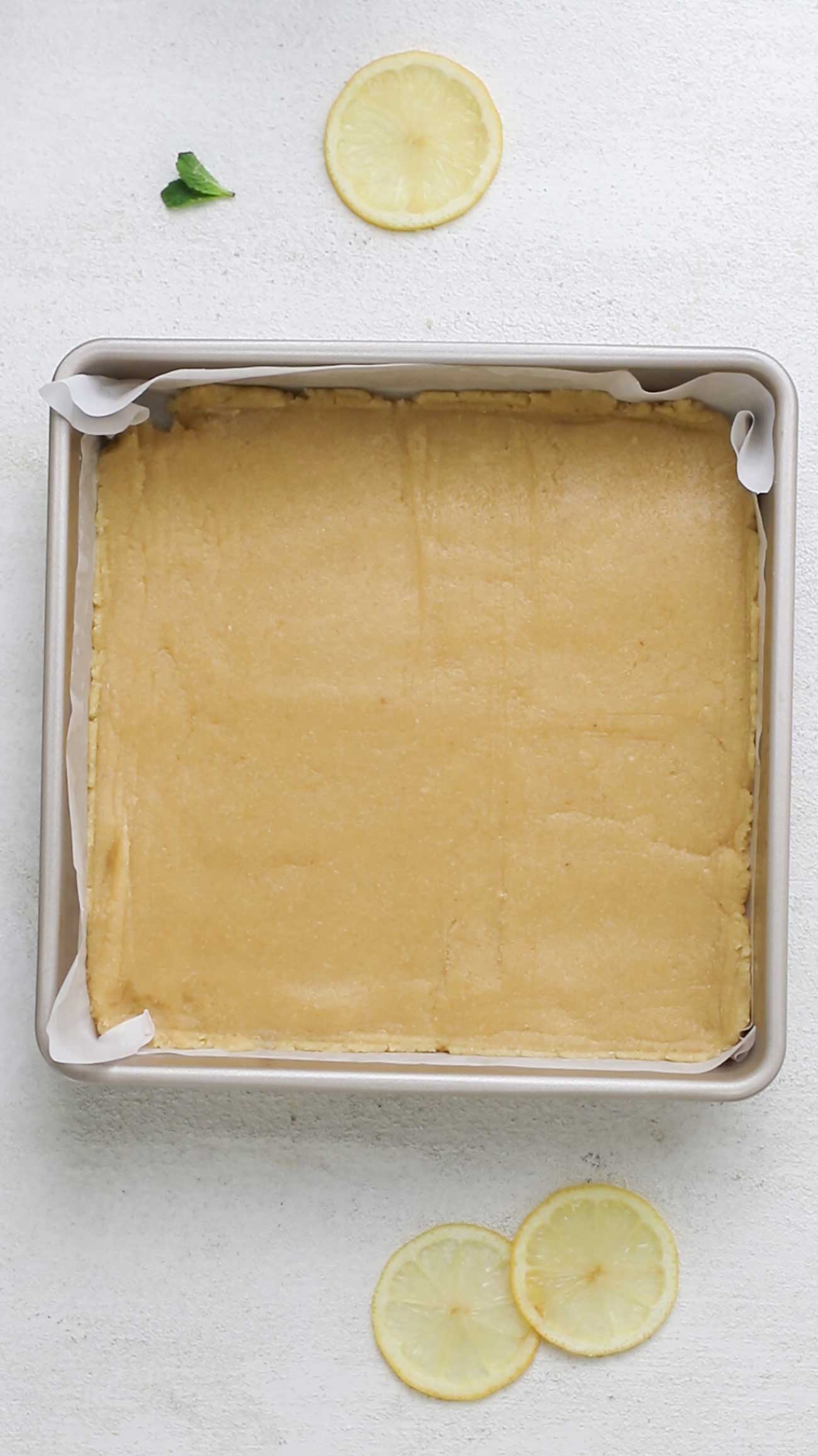 Shortbread crust pressed in a flat layer in a baking pan.