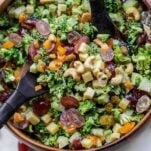 A broccoli salad loaded with grapes, cashews, cheese, and cashews in a creamy dressing.