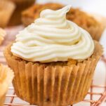 A thick swirl of cream cheese frosting on top of a cupcake.