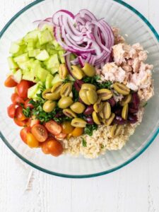 The quinoa in a large bowl with salad ingredients.