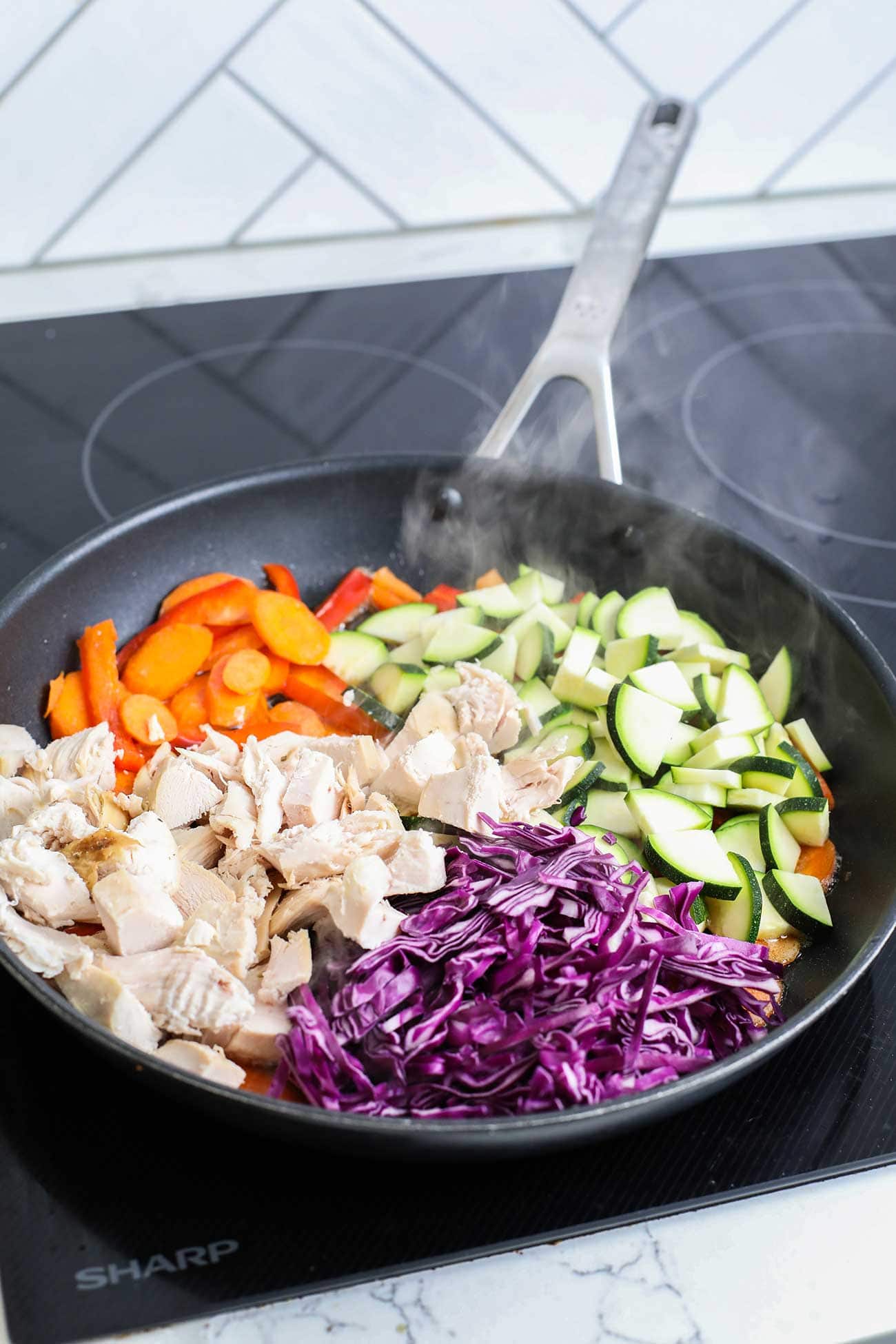 Showing how to stir fry vegetables and heat chicken in a skillet.