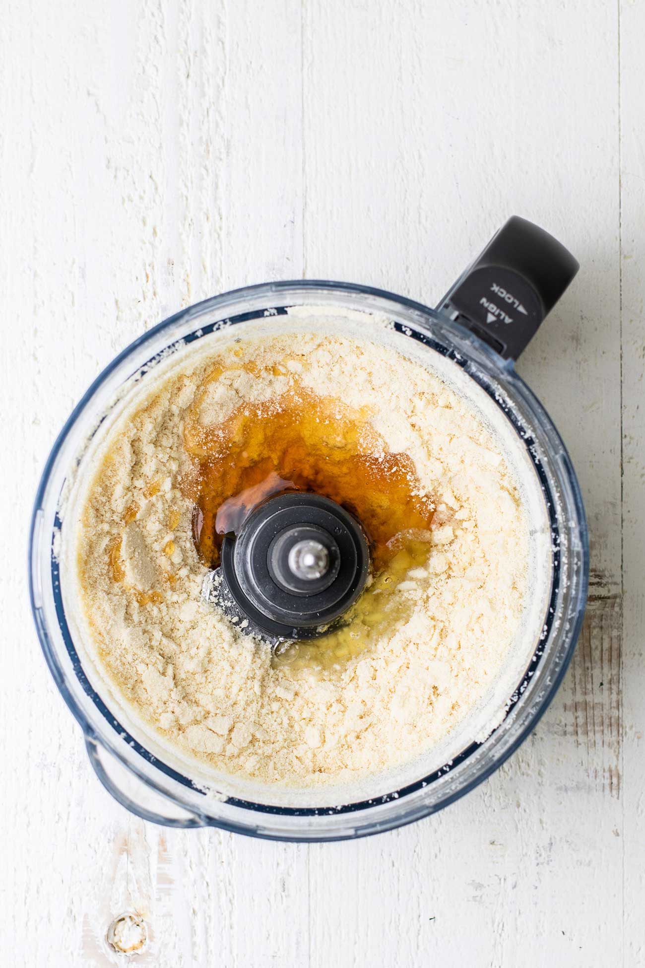 The food processor bowl with the butter and almond flour mixture, with honey and egg white added.