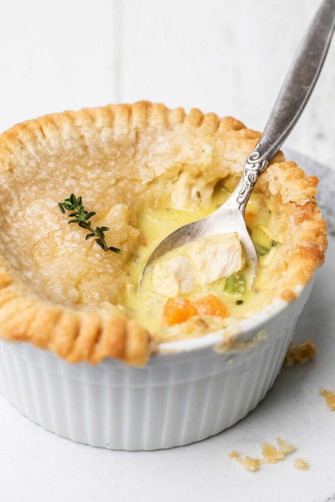 A spoon scooping out some filling from a gluten free chicken pot pie.