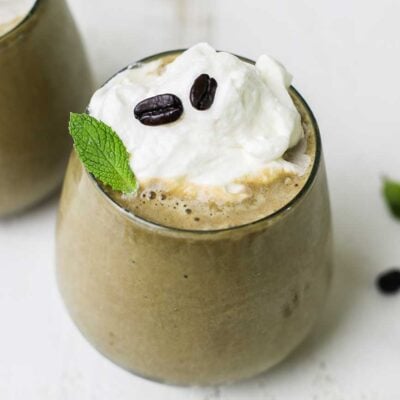 A creamy banana coffee smoothie shown garnished with espresso beans.