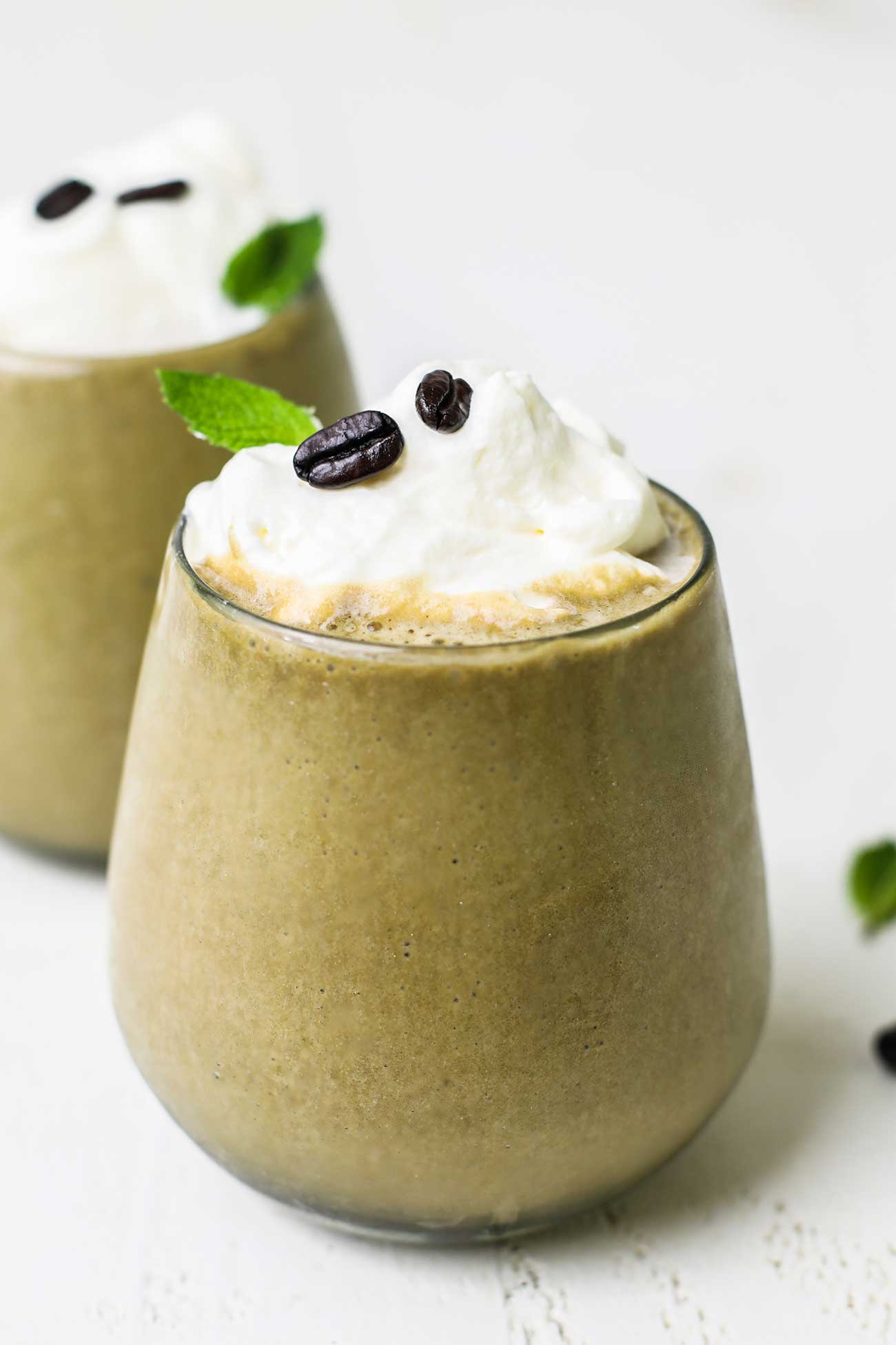 A thick and creamy Banana Coffee Smoothie shown garnished with whipped cream.